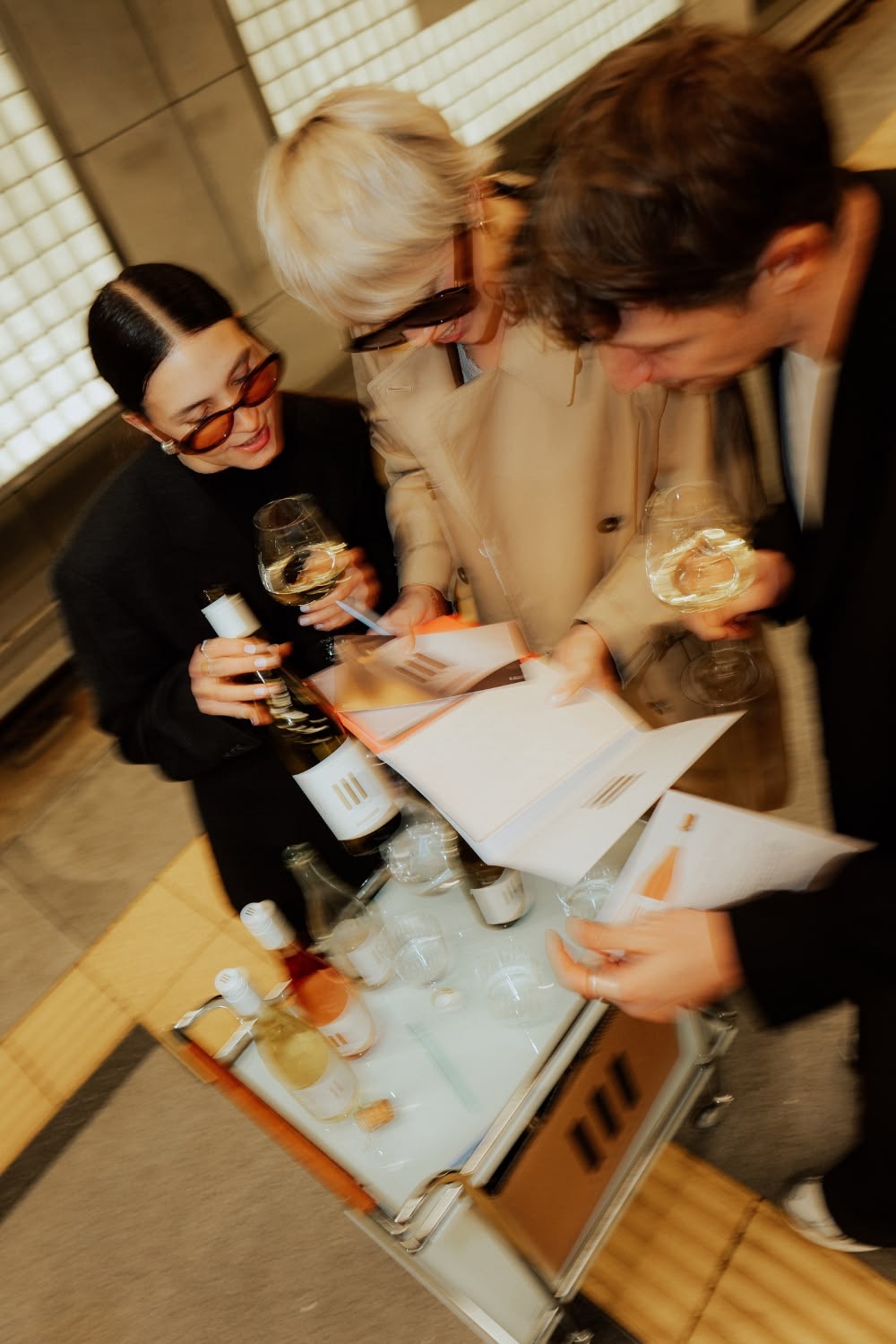 Trois invités discutent autour d'un verre de vin